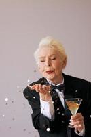 short hair stylish senior woman in tuxedo with glitter celebrating new year. Fun, lifestyle, style, age concept photo