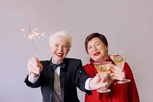 Two beautiful stylish mature senior women celebrating new year. Fun, party, style, celebration concept photo