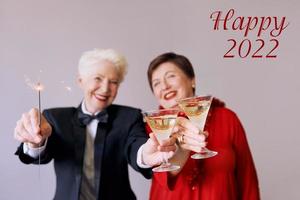 dos hermosas mujeres mayores maduras con estilo celebrando el año nuevo. diversión, fiesta, estilo, concepto de celebración foto