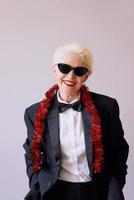 Beautiful stylish mature senior woman in sunglasses and tuxedo celebrating new year. Fun, party, style, celebration concept photo