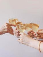 año nuevo celebrando las manos con copas de vino espumoso blanco. navidad, familia, amigos, celebrando, concepto de año nuevo foto