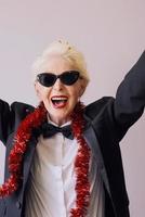 Beautiful stylish mature senior woman in sunglasses and tuxedo celebrating new year. Fun, party, style, celebration concept photo