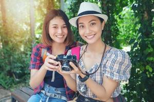 Asian women backpacks walking together and happy  are taking photo and looking picture ,Relax time on holiday concept travel