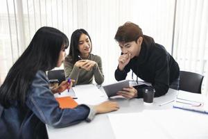 Los estudiantes del grupo sonríen y se divierten y el uso de la tableta también ayuda a compartir ideas en el trabajo y el proyecto. y también revisar el libro antes del examen foto