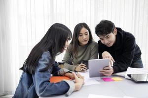 Group Students Smile and have fun and using tablet It also helps to share ideas in the work and project. And also review the book before the exam photo