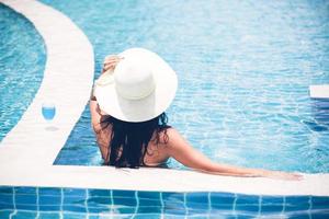 Women wear bikinis and drinking cocktails in the hot summer at the swimming pool. photo