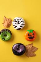 Assortmen of Halloween donuts and autumn leaves photo