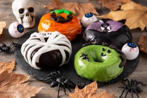 Assortmen of Halloween donuts and autumn leaves photo