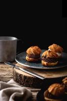 Delicious profiteroles on rustic wooden table photo