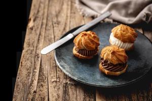 Profiteroles deliciosos sobre mesa de madera rústica foto