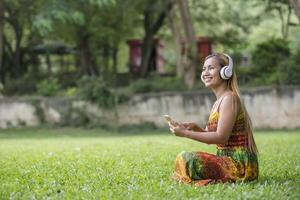 mujer asiática escuchando música favorita en auriculares. tiempo feliz y relax. foto
