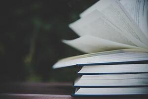 Open book on wooden table outdoors photo