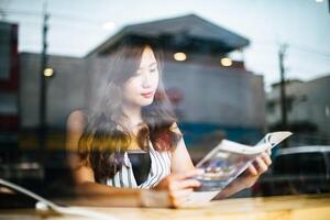 Hermosa mujer leyendo una revista en el café foto