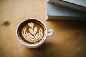 Latte art in coffee cup on the cafe table photo