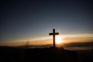 Silhouette of catholic cross and sunrise photo