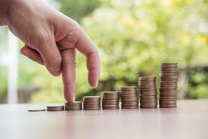 Fingers walking up on coins stack or money stack photo