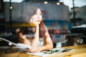 Beautiful woman reading magazine in cafe photo