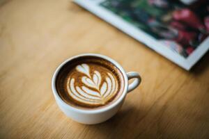 Latte art in coffee cup on the cafe table photo