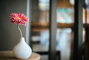 Flor en un jarrón sobre la mesa en la cafetería. foto