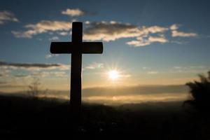 silueta de la cruz católica y el amanecer foto