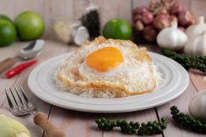 Holy Basil Fried Rice with Chicken Heart and Fried Egg on a White Wooden Floor. photo