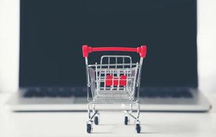 shopping cart with laptop on the desk photo