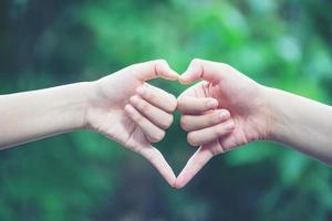 women making heart shapes with their hands photo