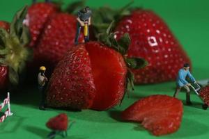 Trabajadores de la construcción en imágenes conceptuales de alimentos con fresas foto