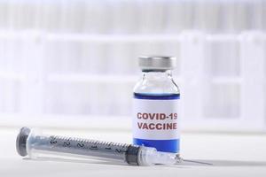 Vacuna contra el virus covid-19 inyectada en un vial listo para administrar en blanco foto