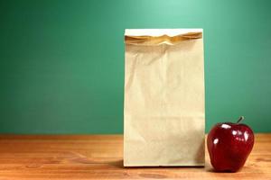 Saco de almuerzo escolar sentado en el escritorio del profesor foto