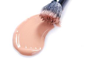 Smeared Liquid Beige Make Up Foundation on White Background photo