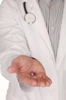 Doctor caucásico con medicación en la mano extendiendo la mano foto
