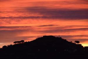 red sunset sky over the hill photo
