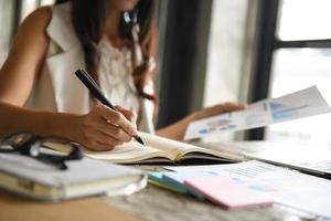 Executives are checking data from graphs and taking notes. photo