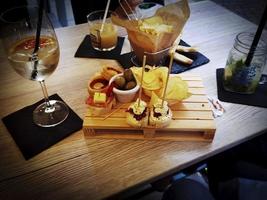 aperitivo en la mesa con bebidas y aperitivos para comer y disfrutar en un día de verano en la riviera de Liguria foto