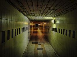 narrow, dark and disturbing corridor of a road underpass in an Italian city photo