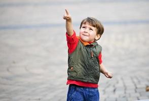 Little boy playing along on city photo