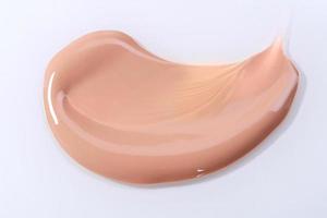 Smeared Liquid Beige Make Up Foundation on White Background photo