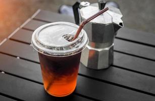 Ice americano coffee in plastic glass from Asian style street cafe. photo