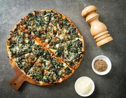 spinach and cheese pizza on wood tray photo