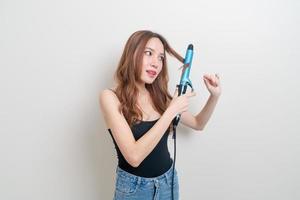 portrait beautiful Asian woman using hair curler or curling iron photo