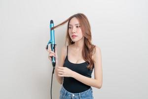 portrait beautiful Asian woman using hair curler or curling iron photo