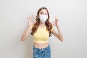 portrait beautiful woman wearing mask with ok or agree hand sign photo