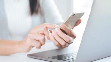 mujer asiática joven que usa el teléfono inteligente escribiendo, charlando conversación. red social, concepto de tecnología foto