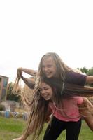 Two girls laugh and spin - carefree and fun time and friendship photo