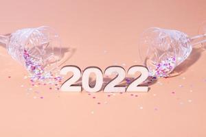 plano festivo de año nuevo con números 2022 y sombras duras con gafas y decoración brillante foto