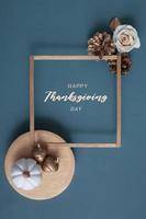 Happy Thanksgiving lettering with flat lay golden pumpkins and acorns on a turquoise background photo
