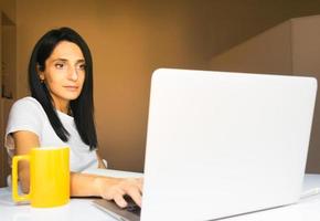 young caucasian woman by computer work from home photo