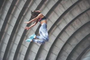 mujer haciendo parkour en la ciudad en un día soleado. foto