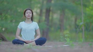 Aziatisch meisje dat 's ochtends yoga doet in de tuin aan het strand